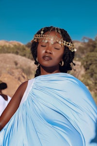 a woman in a blue dress with a crown on her head