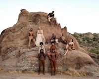 a group of people posing on top of a large rock