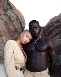 a man and woman posing in front of rocks